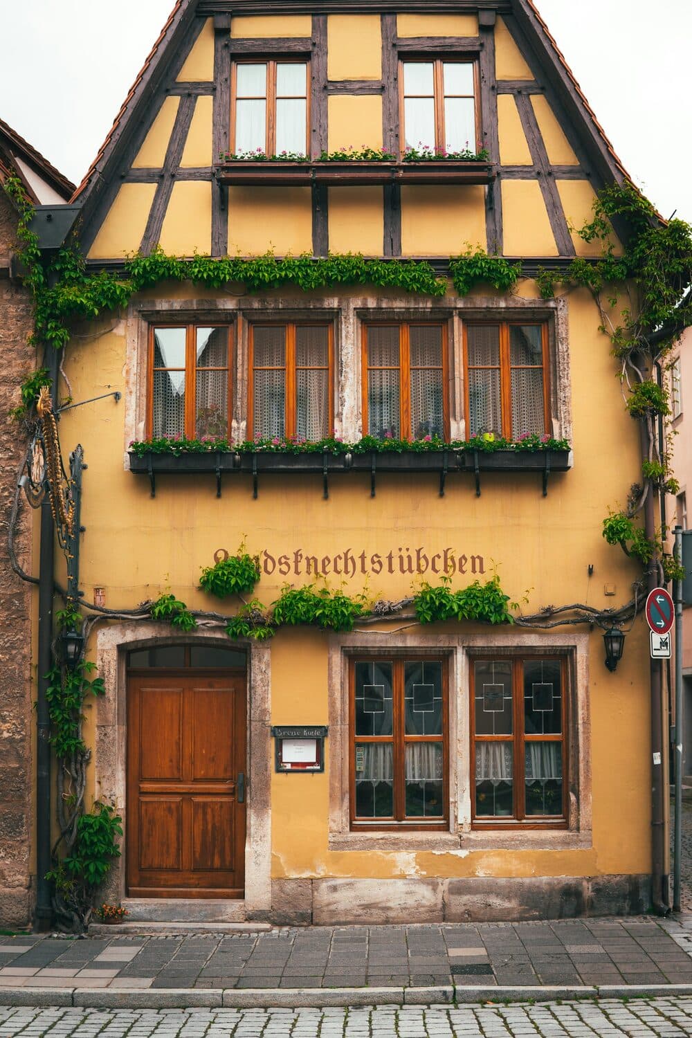 Fachwerkhaus mit grünen Fensterläden und Blumenschmuck